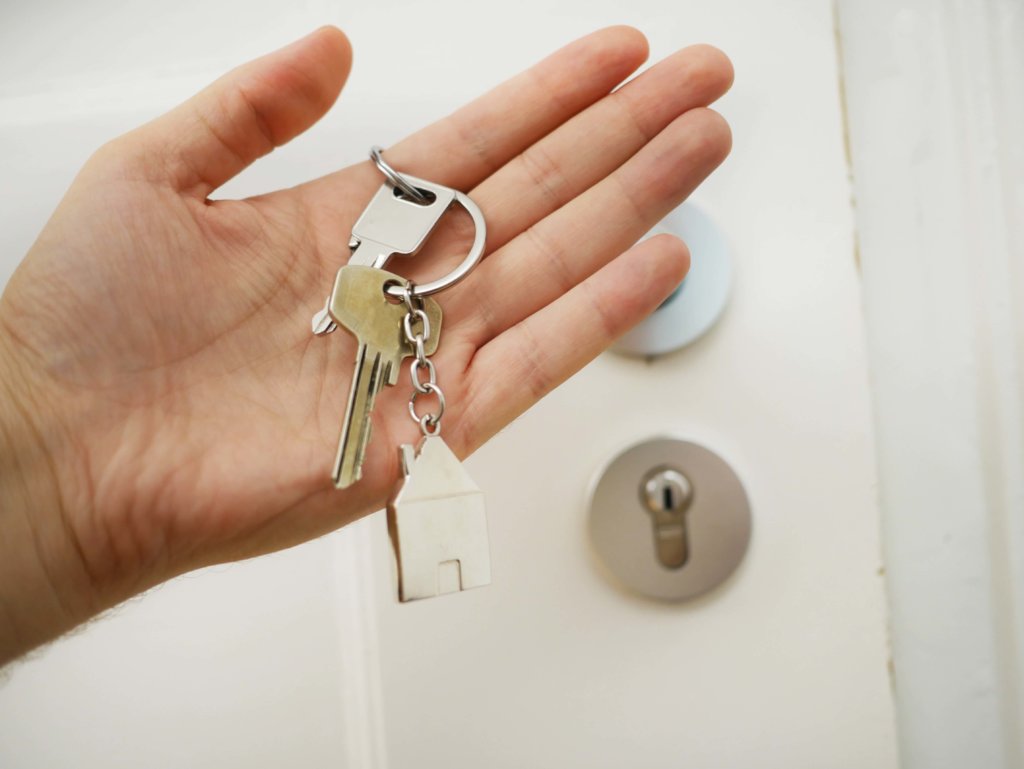 Mazzo di chiavi tenuto in mano, di fronte ad una serratura.
